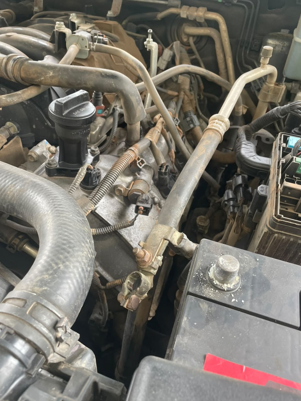 Engine bay with hoses, battery terminal and wiring inspected during vehicle diagnosis
